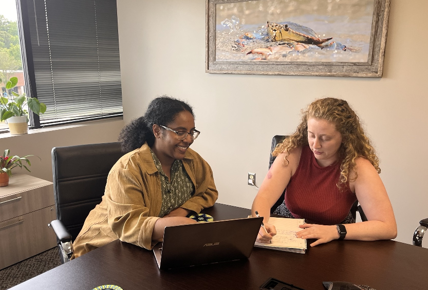 Intern Leah Woldemariam (from George Mason University) working at Further Digital (L) and pictured with Shelby Steere (R).