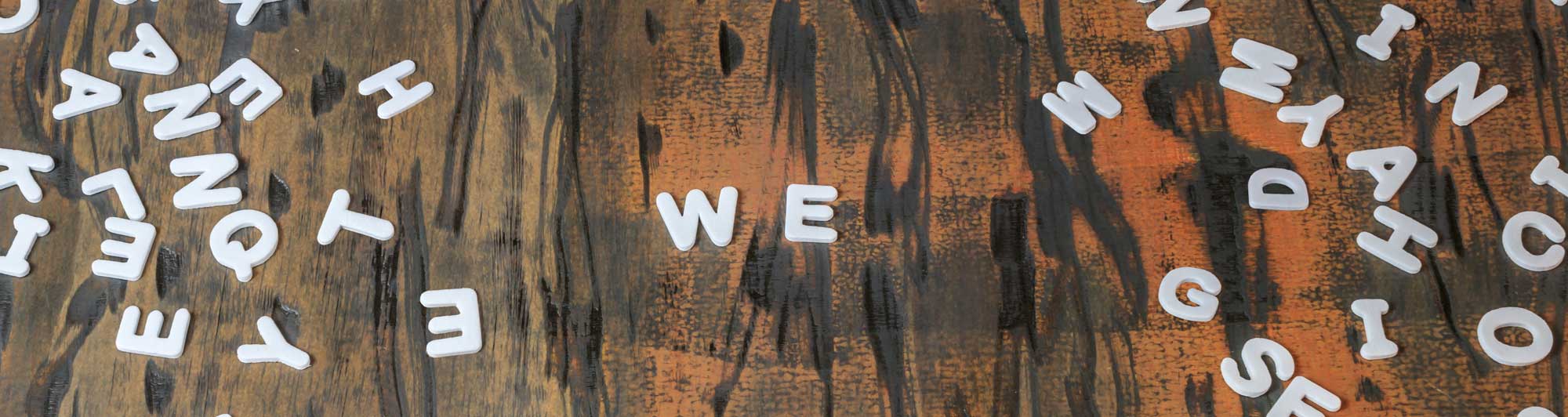 Plastic letters scattered on a table with the word "we" in the center