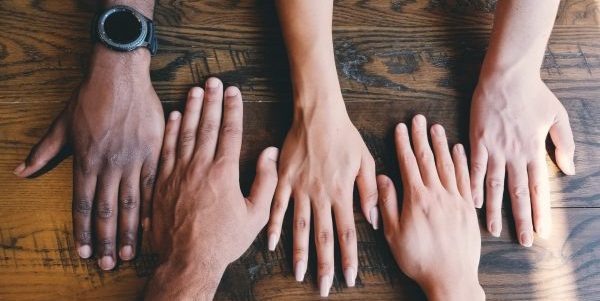 Various Hands reach towards each other on a table